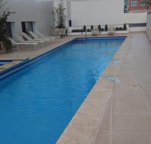 a large blue swimming pool in a building at DUPLEX 5 min de Alphaville in Barueri