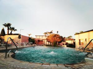 a large swimming pool in a courtyard with a resort at Hotel Eros in Vulcano