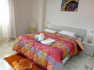 - une chambre avec un grand lit et une couverture colorée dans l'établissement Appartamento Vela Azzurra, à Peschici
