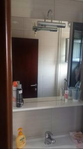 bagno con lavandino e specchio di Brand New Apt in City Center a Bitola