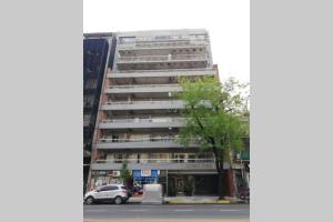 un edificio alto con coches estacionados frente a él en AiresSoho1160 en Buenos Aires