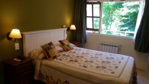sypialnia z dużym łóżkiem i oknem w obiekcie Casa los Tilos w mieście Valeria del Mar
