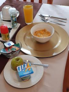 a table with two plates of food and a bowl of cereal at Harmony Guesthouse in Nelspruit