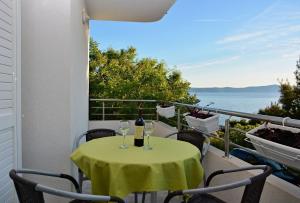 una mesa con 2 copas de vino en el balcón en Apartments Ivi - 100 m from pebble beach, en Drasnice