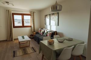 ein Wohnzimmer mit einem Tisch und einem Sofa in der Unterkunft Apartamento Cuesta del salado in Caleta de Sebo