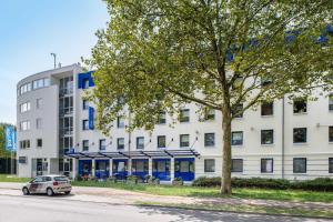 ein weißes Gebäude mit einem davor geparkt in der Unterkunft ibis budget Karlsruhe in Karlsruhe
