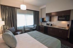 une chambre d'hôtel avec un lit et une cuisine dans l'établissement Brent House Hotel, à La Nouvelle-Orléans