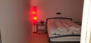 a bedroom with a bed and a red light at Bed & Breakfast Torshavn in Tórshavn