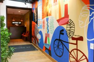 サンパウロにあるHostel More SPの壁に自転車の壁画が施された廊下