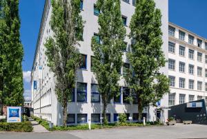 um edifício branco com árvores em frente em ibis budget Nürnberg City Messe em Nurembergue