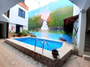 a swimming pool in a house with a painting on the wall at Hotel sueño Tropical in Tarapoto