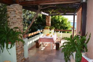 a patio with a table and chairs under a pergola at Apartment in Cala Gonone 26346 in Cala Gonone