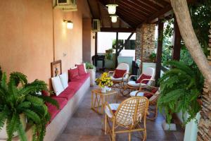 a porch with a red couch and chairs on a patio at Apartment in Cala Gonone 26346 in Cala Gonone