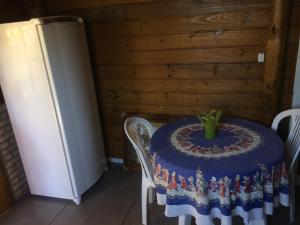 a table with a blue table cloth on it next to a refrigerator at Mandala Chalés in Guarda do Embaú