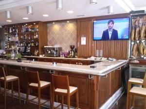 bar z telewizorem z płaskim ekranem nad nim w obiekcie Hostal el Volao w mieście Villanueva de Córdoba