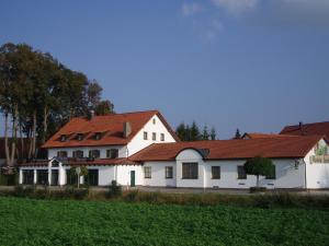 une grande maison blanche avec un toit rouge dans l'établissement Hotel Hutzenthaler, à Bruckberg