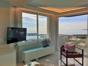 uma sala de estar com televisão e uma grande janela em FABULOUS APARTMENT IN FRONT OF SEA & MARINA WITH INCREDIBLE VIEWS em Estepona