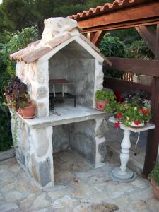 a stone fireplace with a table and potted plants at Apartments Luka in Tisno