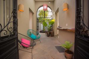 a hallway with chairs and plants in a house at Hotel Mamá Carlota in Querétaro