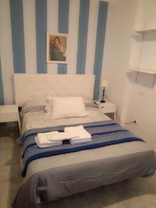 Schlafzimmer mit einem Bett mit blauen und weißen Streifen in der Unterkunft Leps Primera Linea las Canteras in Las Palmas de Gran Canaria