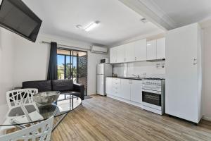uma cozinha e sala de estar com uma mesa e um sofá em Tasman Holiday Parks - Torquay Palms em Hervey Bay