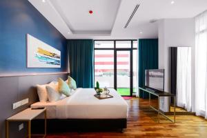 ein Schlafzimmer mit einem großen Bett und einem Fernseher in der Unterkunft SAVV HOTEL in George Town