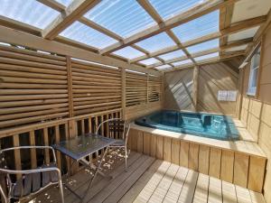 a hot tub in a room with a table and chairs at Parakai Geothermal Motel in Parakai