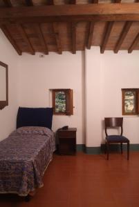 SettignanoにあるVilla Morghenのベッドルーム1室(ベッド1台、椅子付)