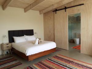 a bedroom with a large bed and a bathroom at The Hidden Spring in Wanaka