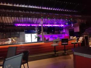 a bar in a restaurant with purple lighting at Macura Resort in Ko Chang