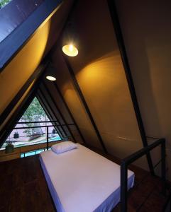 a small bed in a room with a window at Kottawatta River Bank Resort in Udawalawe