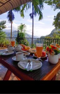 una mesa con platos de comida y bebidas. en V@Ella guesthouse, en Ella