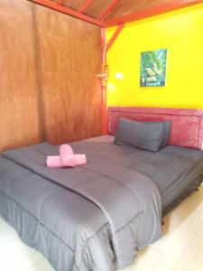 a bed with a pink hat on top of it at Tereng Wilis Jungle Inn in Tetebatu