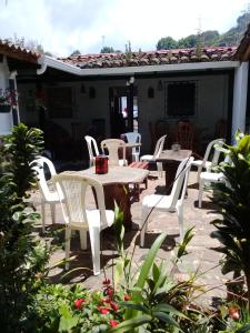 eine Gruppe von Tischen und Stühlen auf einer Terrasse in der Unterkunft Portal de los Farolitos in Concepción de Ataco