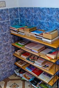 a stack of books sitting on a shelf at Dar Bleu Pearl in Chefchaouen