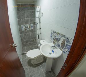 a bathroom with a toilet and a sink at Kimaná Hostal in Santa Rosa de Cabal