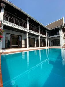 a swimming pool in front of a house at Meunna Boutique Hotel in Luang Prabang