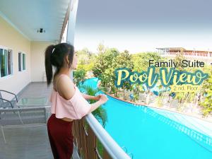 Una joven parada en un balcón con vistas a la piscina en Khao Yai Fantasy Resort en Nong Nam Daeng