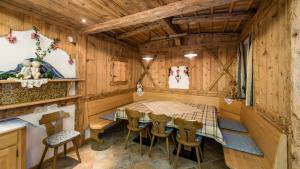 a dining room in a log cabin with a table and chairs at Residence Treyer in Terento