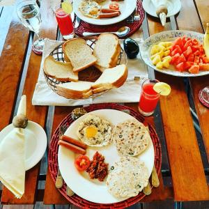 een tafel met borden ontbijtproducten erop bij Elephant Lodge in Udawalawe