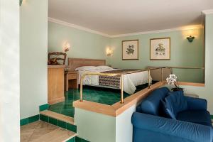 a bedroom with a bed and a blue couch at Hotel Continental Ischia in Ischia