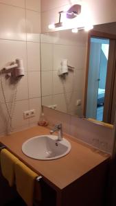 a bathroom with a sink and a mirror at Hotel Central in Erlangen