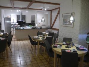 ein Esszimmer mit Tischen und Stühlen und eine Küche in der Unterkunft Hotel Central in Erlangen