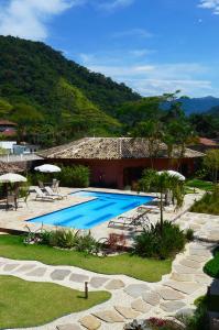 un complejo con piscina y un edificio en Pousada Tupinamba en Juquei