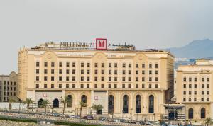 a large building with cars parked in front of it at Millennium Makkah Al Naseem in Mecca