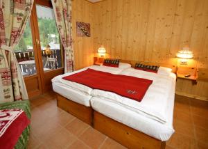 Postel nebo postele na pokoji v ubytování Albergo Alpenrose Ski&Bike Mountain Hotel