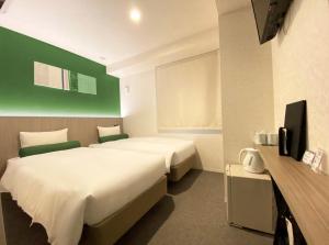 Een bed of bedden in een kamer bij Doutonbori Crystal Hotel IV
