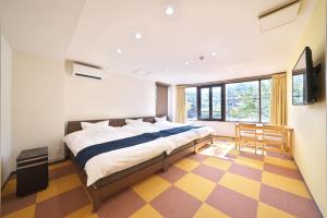 a bedroom with a bed and a checkered floor at Kanazawaya in Kanazawa