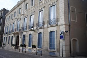 un grand bâtiment avec des balcons sur le côté d'une rue dans l'établissement CENTRE HISTORIQUE T3 DUPLEX PARKING Gratuit, à Béziers