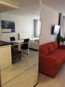 un salon avec un canapé rouge et une chambre dans l'établissement 305 Berlin, Studio Apartment, 38m2 2-4 Pers, à Klagenfurt am Wörthersee